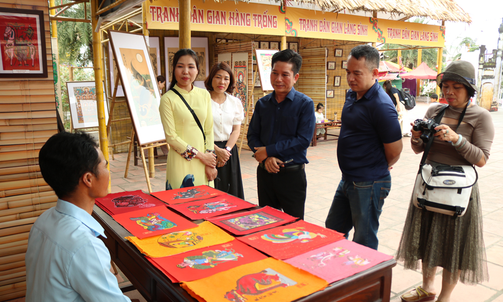 Du kh&aacute;ch tham quan v&agrave; t&igrave;m hiểu về tranh d&acirc;n gian Kim Ho&agrave;ng tại triển l&atilde;m.