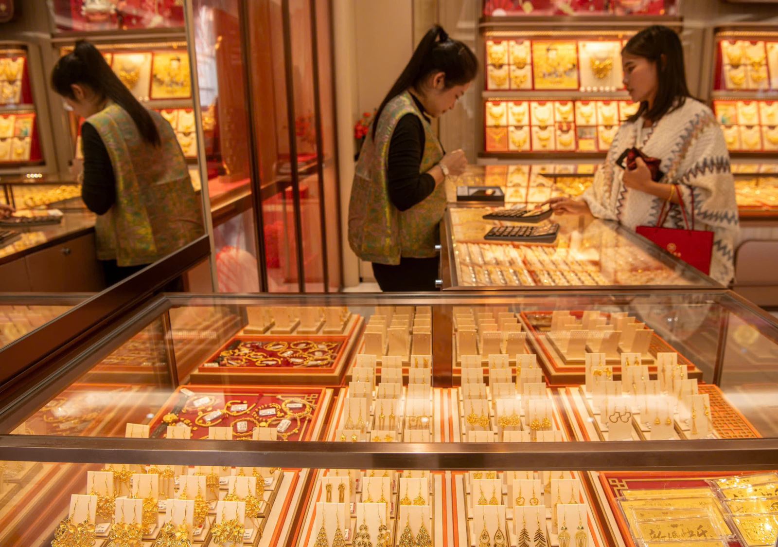 Kh&aacute;ch h&agrave;ng chọn mua trang sức v&agrave;ng tại cửa h&agrave;ng ở Hải Nam, Trung Quốc. Ảnh: THX/TTXVN.