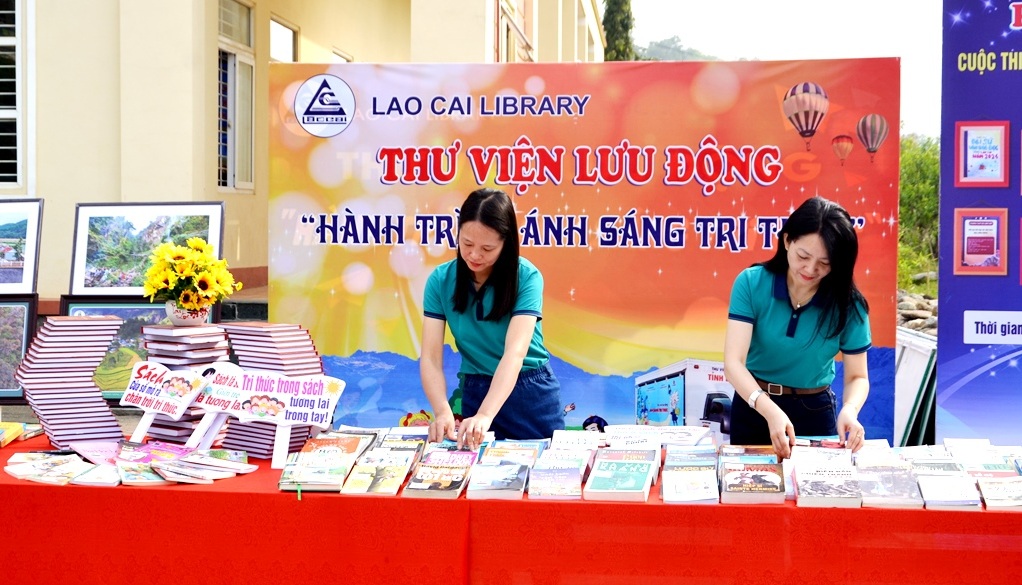 C&aacute;n bộ Thư viện tỉnh L&agrave;o Cai phục vụ học sinh đọc s&aacute;ch lưu động ngay tại s&acirc;n trường trong lễ ph&aacute;t động. Ảnh: Quốc Hồng