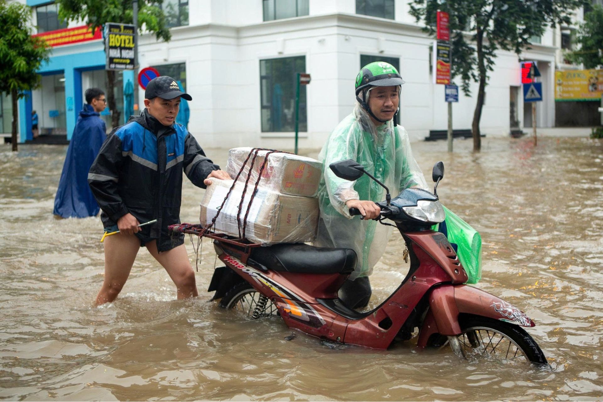 Người d&acirc;n chật vật di chuyển giữa tuyến phố ngập s&acirc;u sau mưa lớn &ndash; thực trạng cho thấy &aacute;p lực cấp thiết phải n&acirc;ng cấp hạ tầng tho&aacute;t nước đ&ocirc; thị.