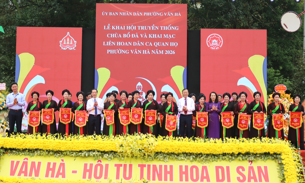 C&aacute;c đại biểu trao cờ lưu niệm cho đại diện c&acirc;u lạc bộ tham gia Li&ecirc;n hoan D&acirc;n ca Quan họ phường V&acirc;n H&agrave; lần thứ I năm 2026.