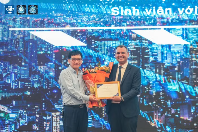 Ph&oacute; Gi&aacute;o sư, Tiến sĩ Nguyễn Tuấn Anh - Ph&oacute; Hiệu trưởng Trường Đại học Kiến tr&uacute;c H&agrave; Nội trao hoa v&agrave; Thư cảm ơn tới &ocirc;ng Sergio Dias Figueiredo - Phu qu&acirc;n Đại sứ Vương Quốc Anh trong chương tr&igrave;nh Business Idea d&agrave;nh cho sinh vi&ecirc;n khối ng&agrave;nh Kinh tế tại Trường Đại học Kiến tr&uacute;c H&agrave; Nội. Ảnh: NTCC