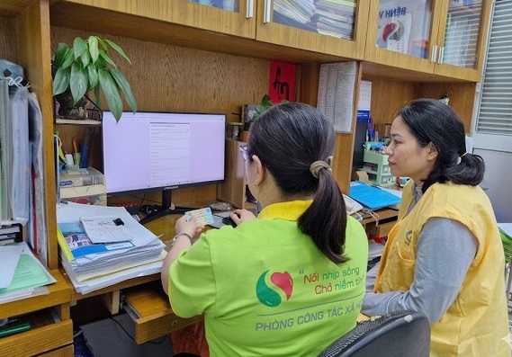 Nh&acirc;n vi&ecirc;n c&ocirc;ng t&aacute;c x&atilde; hội thực hiện hỗ trợ bệnh nh&acirc;n mua BHYT trực tuyến tại bệnh viện