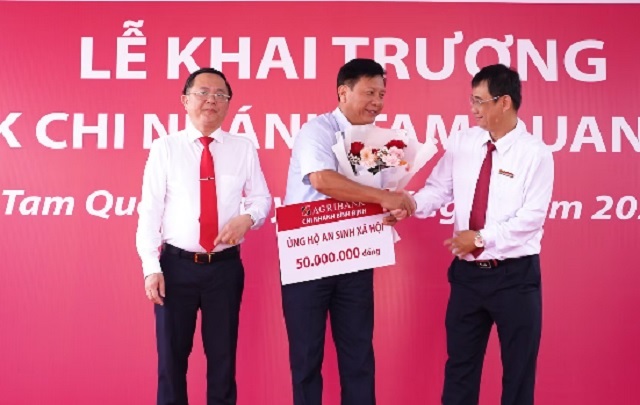 Đại diện phường Tam Quan (đứng giữa) nhận tiền hỗ trợ từ l&atilde;nh đạo Agribank Chi nh&aacute;nh B&igrave;nh Định. Ảnh: DN