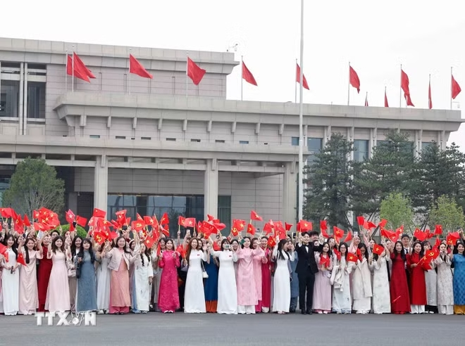 Đại biểu v&agrave; kiều b&agrave;o đ&oacute;n Tổng B&iacute; thư, Chủ tịch nước T&ocirc; L&acirc;m v&agrave; Phu nh&acirc;n tại s&acirc;n bay quốc tế Thủ đ&ocirc; Bắc Kinh. (Ảnh: Thống Nhất/TTXVN)