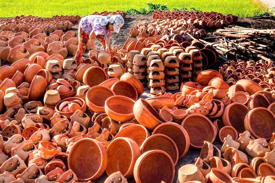 B&agrave; con l&agrave;ng gốm B&igrave;nh Đức, x&atilde; Bắc B&igrave;nh đang sắp xếp c&aacute;c sản phẩm theo tr&igrave;nh tự để chuẩn bị nung gốm