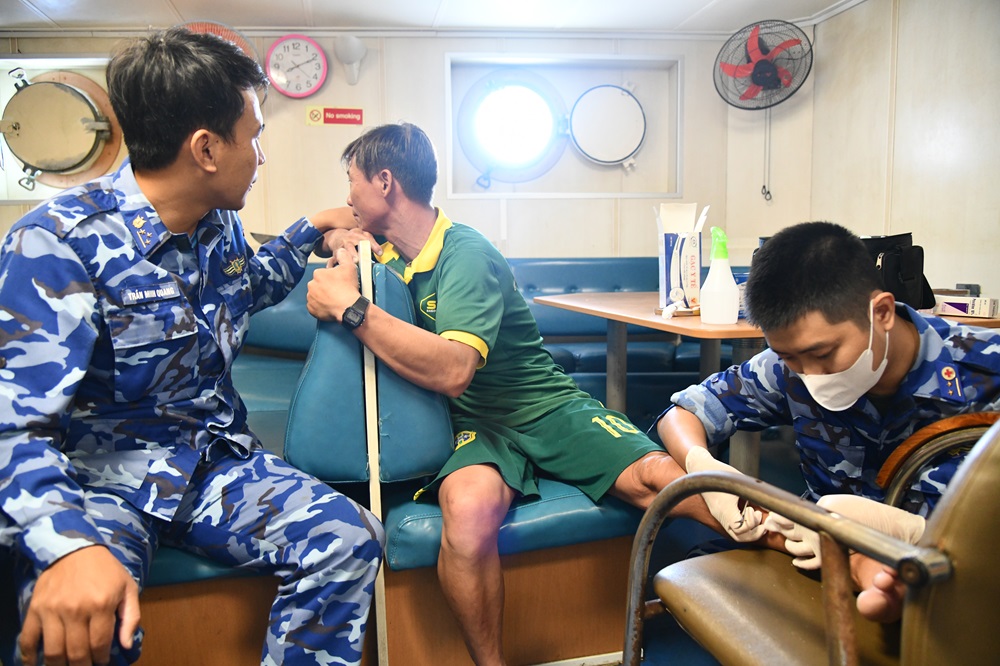 C&aacute;n bộ, chiến sĩ T&agrave;u CSB 9001 xử l&yacute; ổ &aacute;p xe, s&aacute;t tr&ugrave;ng v&agrave; băng b&oacute; cho ngư d&acirc;n bị nạn tr&ecirc;n biển