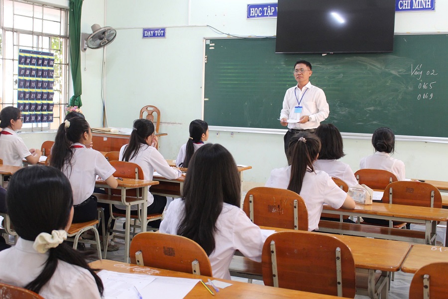 C&aacute;n bộ coi thi hướng dẫn th&iacute; sinh ghi th&ocirc;ng tin tr&ecirc;n giấy thi