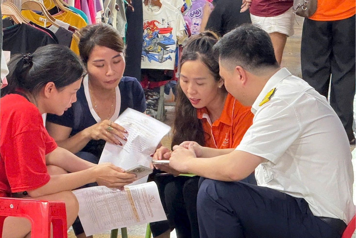 C&ocirc;ng chức Thuế TP. H&agrave; Nội hướng dẫn hộ kinh doanh về việc &aacute;p dụng h&oacute;a đơn điện tử. Ảnh: KT