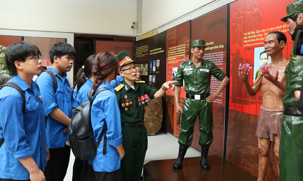 Thế hệ trẻ tham quan trưng b&agrave;y v&agrave; nghe c&aacute;c cựu chiến binh kể chuyện lịch sử.