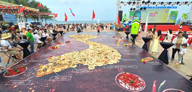 Du kh&aacute;ch h&agrave;o hứng check-in b&ecirc;n chiếc b&aacute;nh pizza khổng lồ m&ocirc; phỏng bản đồ Việt Nam.
