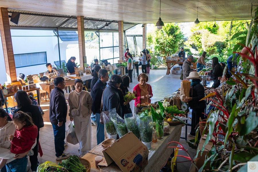Kh&aacute;ch h&agrave;ng chọn mua rau, củ tại gian h&agrave;ng ở Phi&ecirc;n chợ n&ocirc;ng sản hữu cơ Đ&agrave; Lạt, nơi nhịp mua b&aacute;n diễn ra chậm r&atilde;i nhưng ổn định qua từng kỳ chợ.