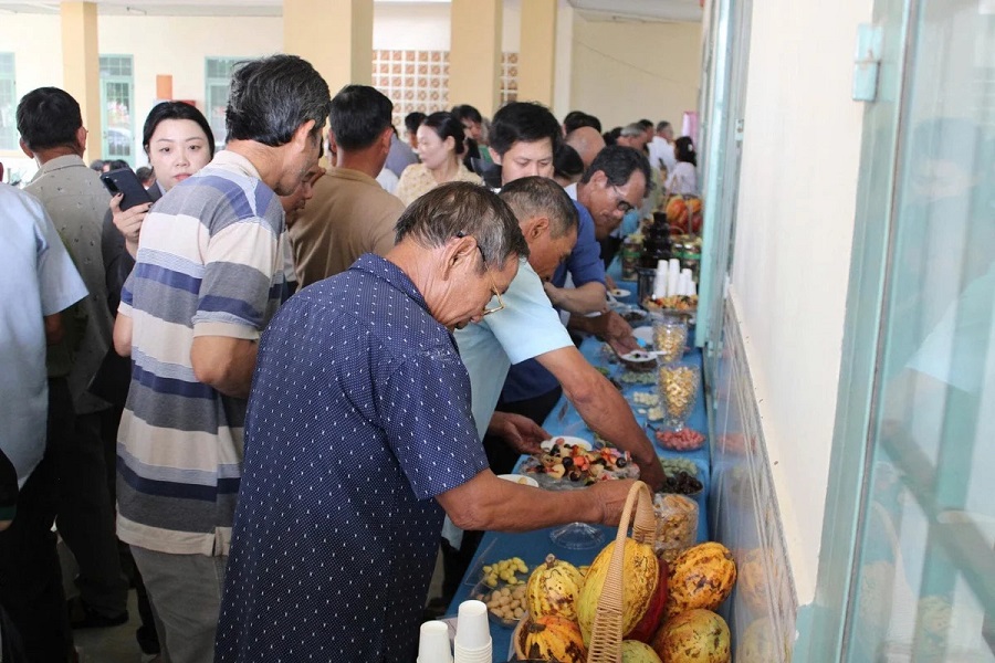 N&ocirc;ng d&acirc;n v&agrave; đại biểu tham quan, t&igrave;m hiểu c&aacute;c sản phẩm từ ca cao v&agrave; một số c&acirc;y trồng được đề xuất chuyển đổi tại tọa đ&agrave;m. Ảnh: N.T.