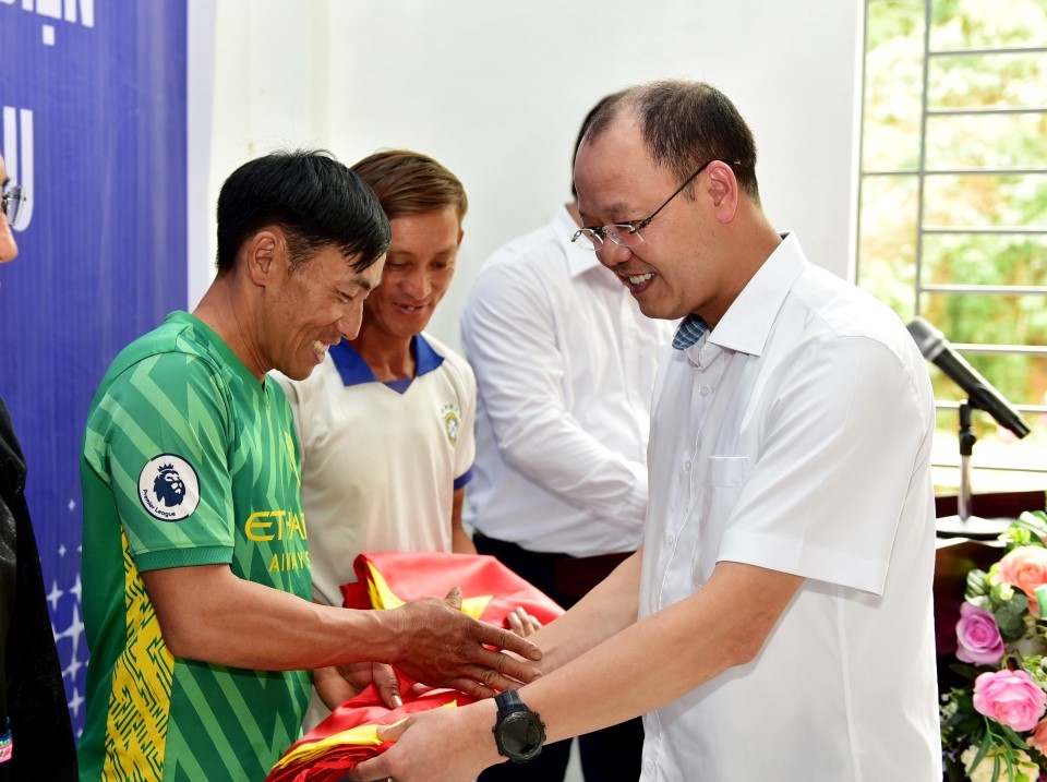 &Ocirc;ng Trần Kim Long &ndash; Gi&aacute;m đốc C&ocirc;ng ty Điện lực Lai Ch&acirc;u tặng cờ Tổ quốc cho c&aacute;c hộ d&acirc;n trong bản
