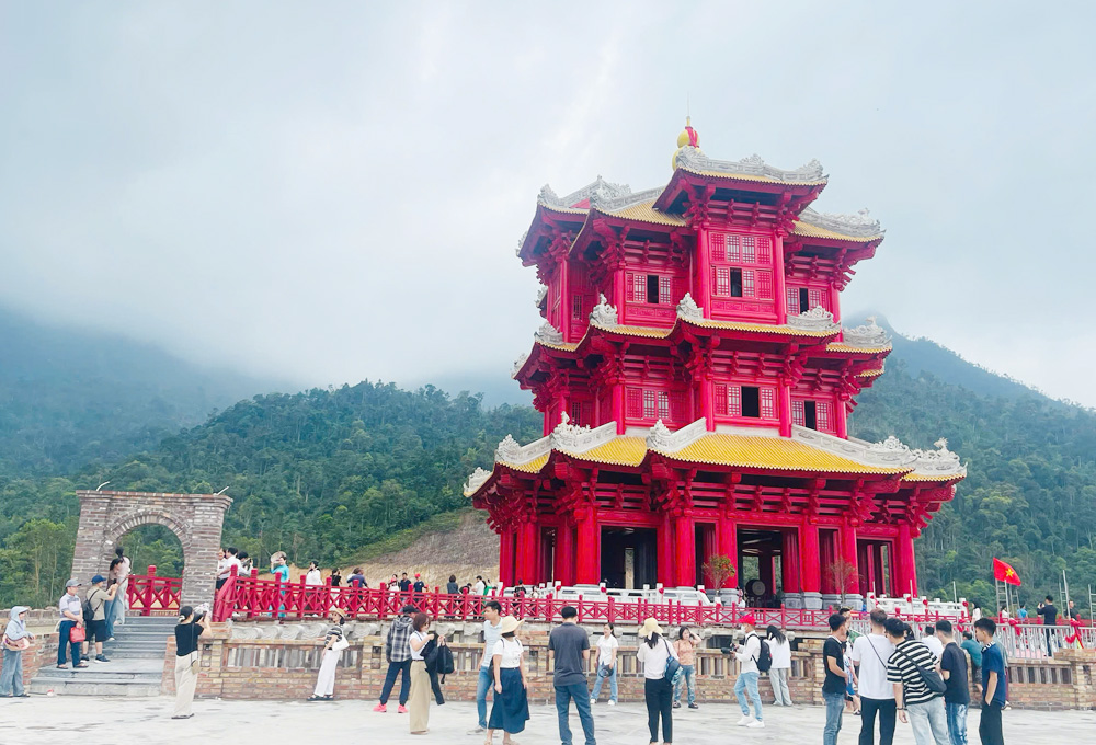 Du kh&aacute;ch tham quan, chụp ảnh b&ecirc;n Th&aacute;p chu&ocirc;ng Hoa Nghi&ecirc;m.