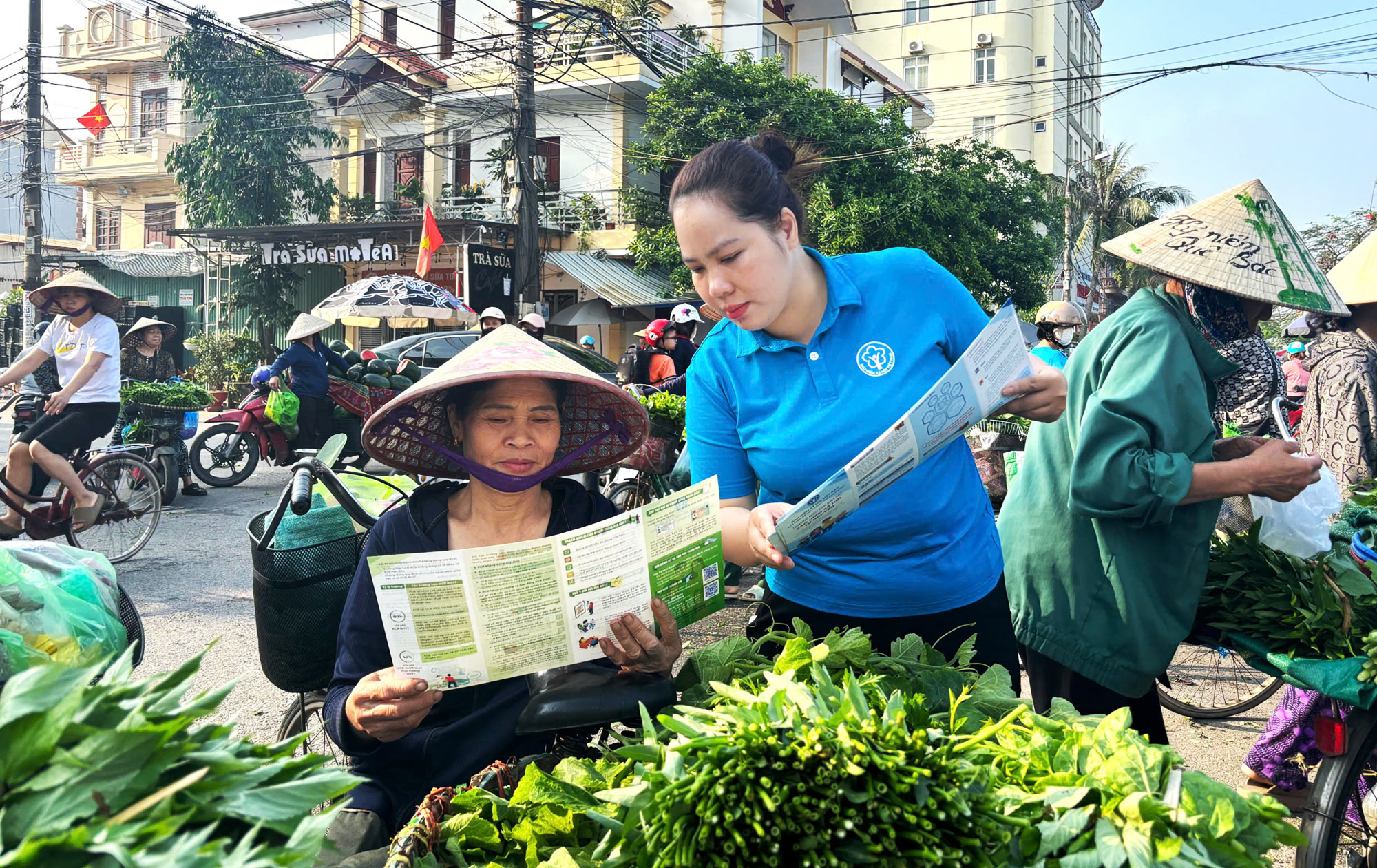 C&aacute;n bộ BHXH th&agrave;nh phố trực tiếp gặp gỡ tiểu thương v&agrave; người d&acirc;n để ph&aacute;t tờ rơi, giải đ&aacute;p c&aacute;c thắc mắc về ch&iacute;nh s&aacute;ch.