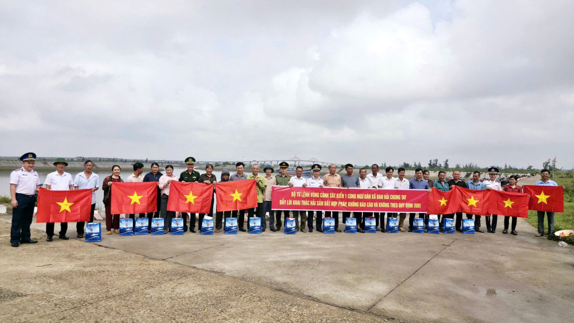 Ảnh 4: C&aacute;n bộ, chiến sĩ Cảnh s&aacute;t biển c&ugrave;ng c&aacute;c lực lượng v&agrave; b&agrave; con ngư d&acirc;n chụp ảnh lưu niệm, k&yacute; cam kết chấp h&agrave;nh nghi&ecirc;m c&aacute;c quy định về khai th&aacute;c hải sản hợp ph&aacute;p, kh&ocirc;ng vi phạm IUU.