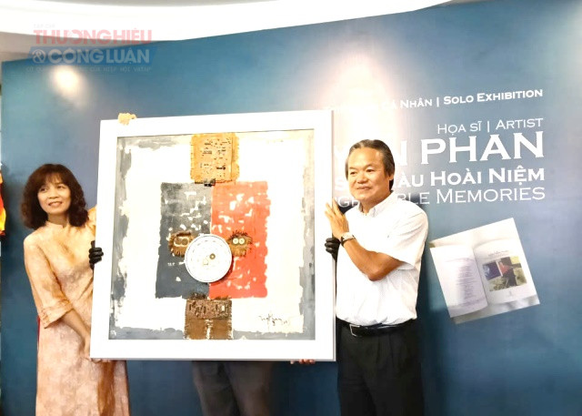 KTS Phan Trường Sơn, con trai cố họa sĩ Nguyễn Phan trao tặng bức tranh sơn dầu &ldquo;Xưa v&agrave; Nay&rdquo; cho b&agrave; Nguyễn Thị Trinh, Ph&oacute; Gi&aacute;m đốc Bảo t&agrave;ng TP.Đ&agrave; Nẵng để trưng b&agrave;y tại Bảo t&agrave;ng Mỹ thuật Đ&agrave; Nẵng . Ảnh: Đ&igrave;nh Kh&aacute;nh.