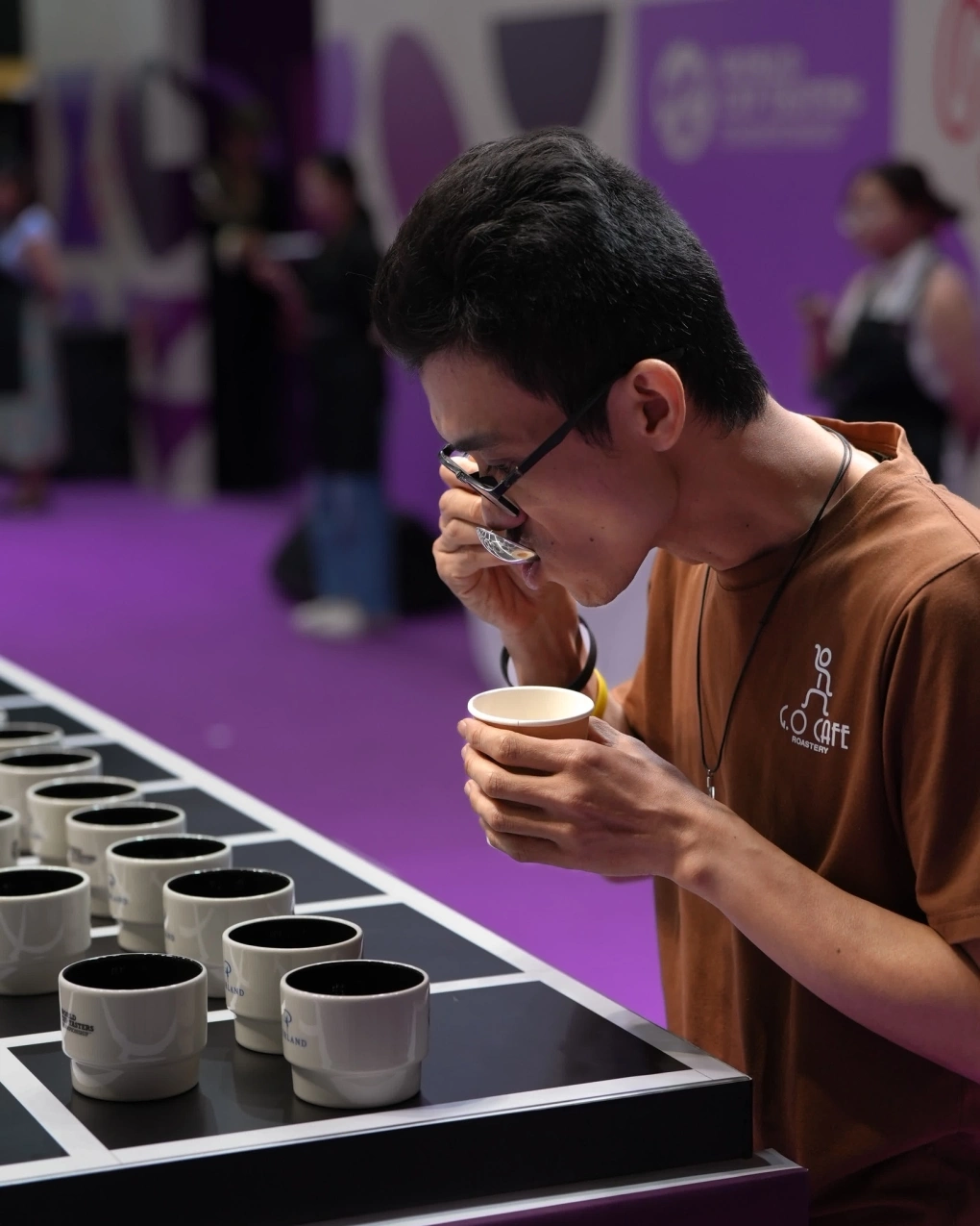 L&ecirc; Quang Cường trong qu&aacute; tr&igrave;nh tham gia thi, trước mặt l&agrave; c&aacute;c bộ c&agrave; ph&ecirc; được xếp th&agrave;nh nh&oacute;m 3 t&aacute;ch, h&igrave;nh tam gi&aacute;c. (Ảnh: BTC)