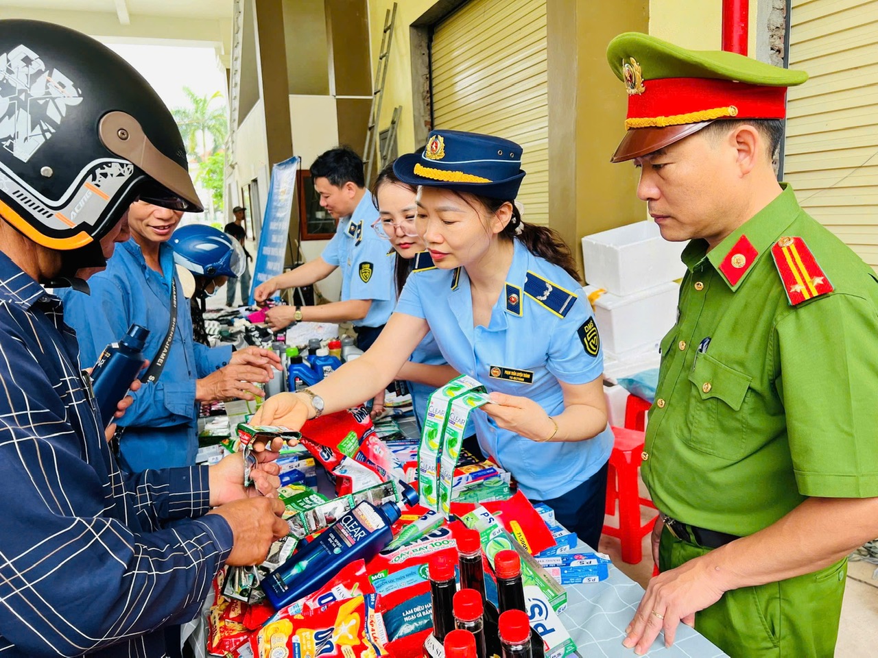 Lực lượng chức năng hướng dẫn người d&acirc;n ph&acirc;n biệt h&agrave;ng thật - h&agrave;ng giả