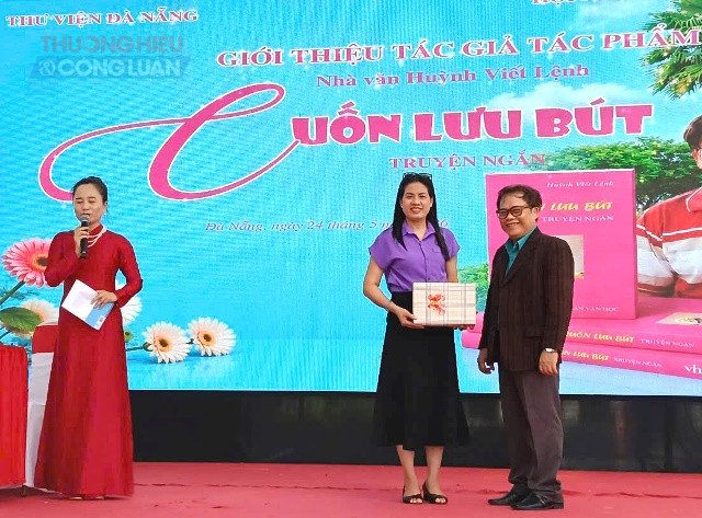 Nh&agrave; văn Huỳnh Viết Lệnh tặng s&aacute;ch cho b&agrave; Vũ Thị &Acirc;n, Ph&oacute; Gi&aacute;m đốc Thư viện Đ&agrave; Nẵng