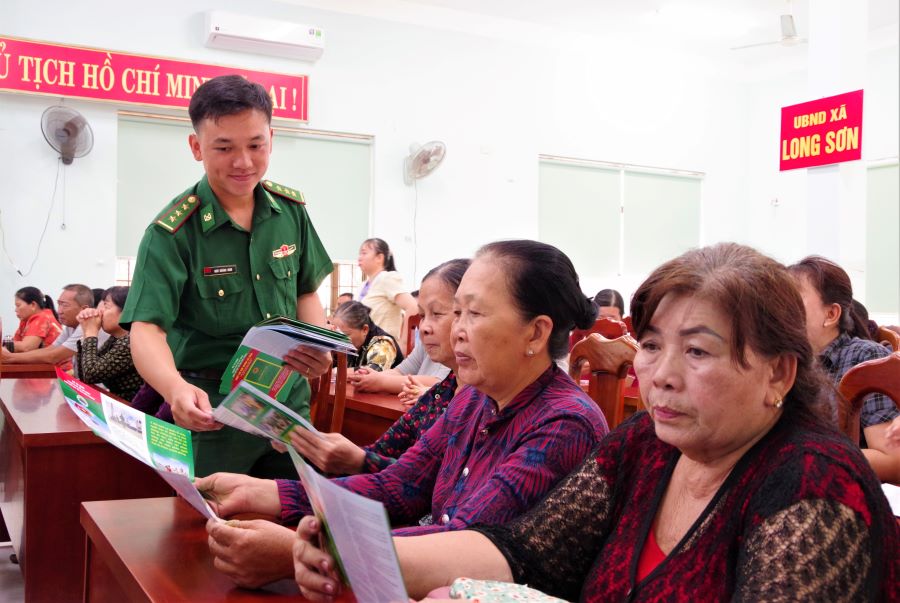 Đ&ocirc;̀n Bi&ecirc;n phòng Long Sơn phát tờ rơi pháp lu&acirc;̣t tuy&ecirc;n truy&ecirc;̀n Lu&acirc;̣t Bi&ecirc;n phòng Vi&ecirc;̣t Nam cho các đại bi&ecirc;̉u tham dự H&ocirc;̣i nghị tại xã Long Sơn, TP.HCM