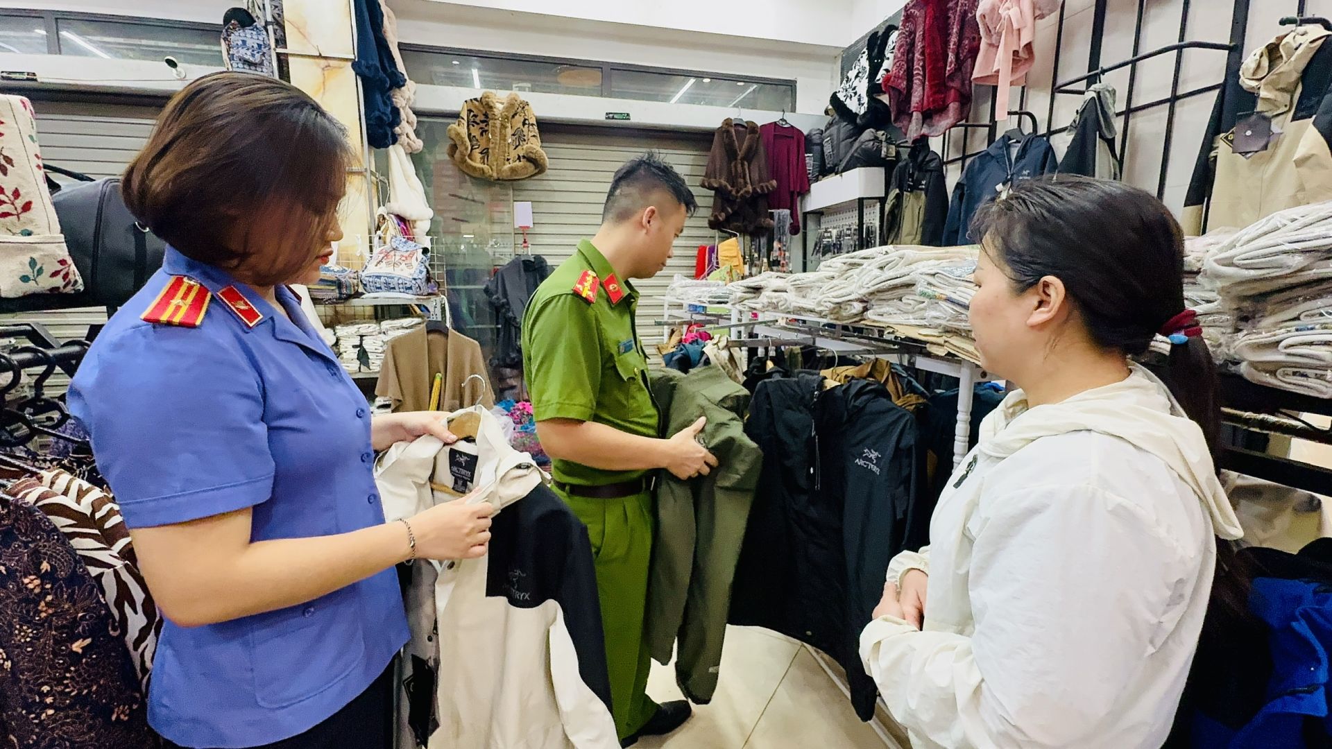 Lực lượng chức năng kiểm tra c&aacute;c mặt h&agrave;ng b&agrave;y b&aacute;n tại cửa h&agrave;ng của b&agrave; Vũ Thị Mận