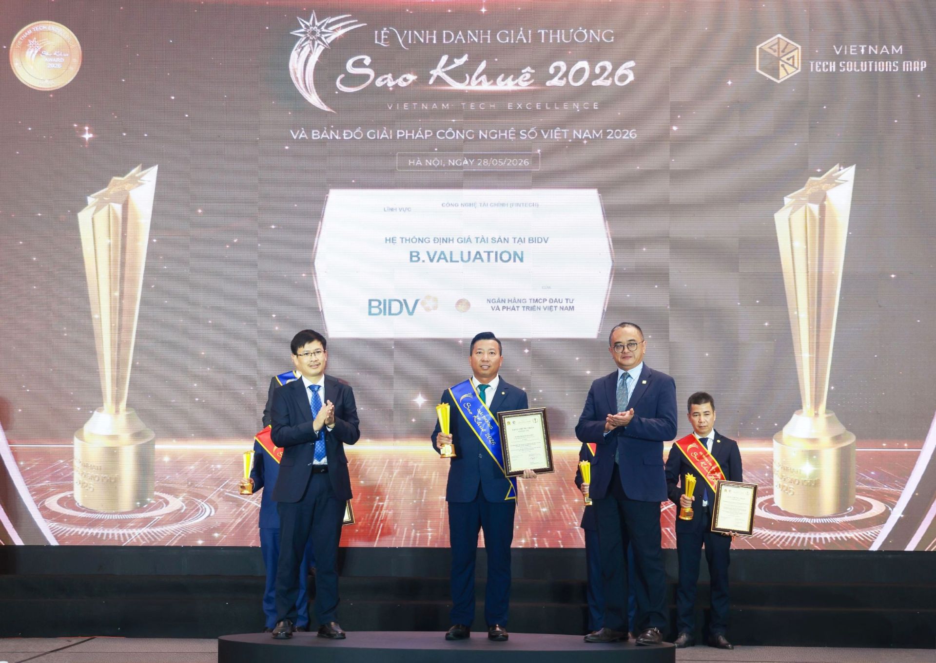 Đại diện L&atilde;nh đạo Trung t&acirc;m Định gi&aacute; t&agrave;i sản ki&ecirc;m L&atilde;nh đạo Ban QLDA X&acirc;y dựng phần mềm Hệ thống định gi&aacute; t&agrave;i sản tại BIDV l&ecirc;n nhận giải thưởng Sao Khu&ecirc; 2026 với sản phẩm B.Valuation