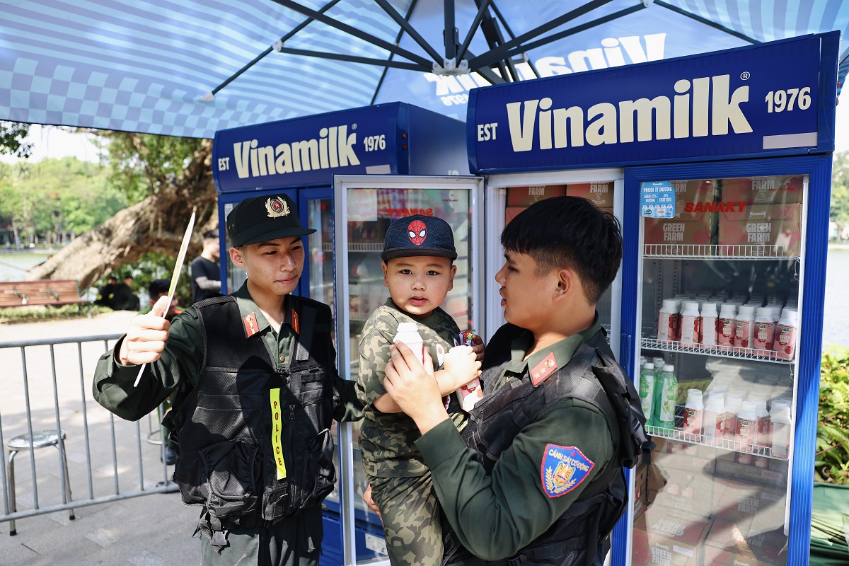 Em b&eacute; được lực lượng cảnh s&aacute;t cơ động chăm s&oacute;c, trao tặng sản phẩm dinh dưỡng Vinamilk tại chương tr&igrave;nh. Ảnh: Vi Nam
