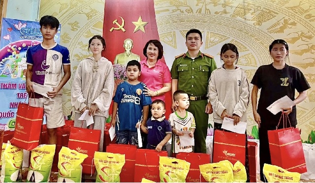 B&agrave; Đồng Thị &Aacute;nh (thứ 4 từ tr&aacute;i qua) trao qu&agrave; cho c&aacute;c ch&aacute;u thiếu nhi. Ảnh: L&acirc;m Vi.
