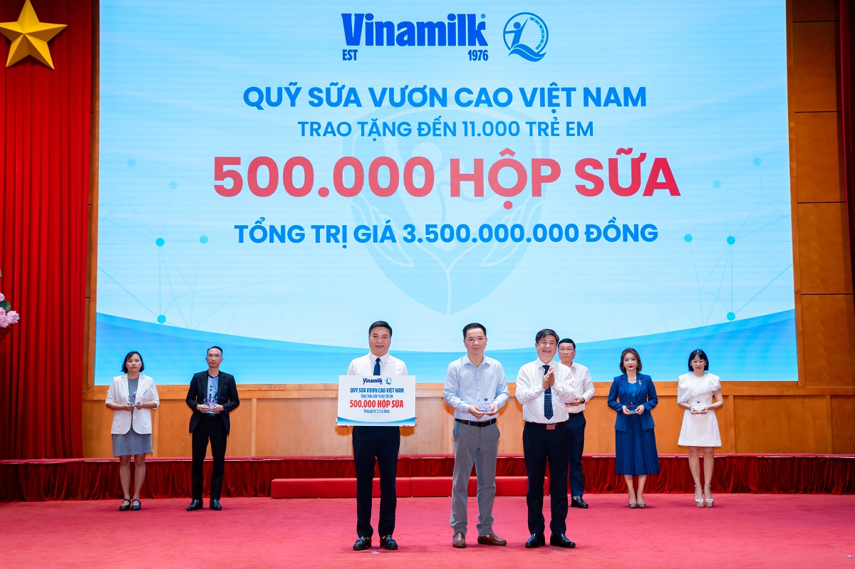 Đại diện Vinamilk (đứng giữa) trao bảng tượng trưng 500.000 hộp sữa v&agrave; nhận kỷ niệm chương từ Bộ Y tế (Ảnh: VN).