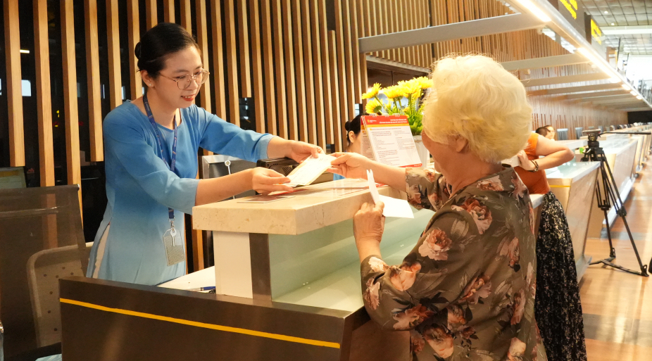 Nh&acirc;n vi&ecirc;n hỗ trợ h&agrave;nh kh&aacute;ch l&agrave;m thủ tục l&ecirc;n m&aacute;y bay