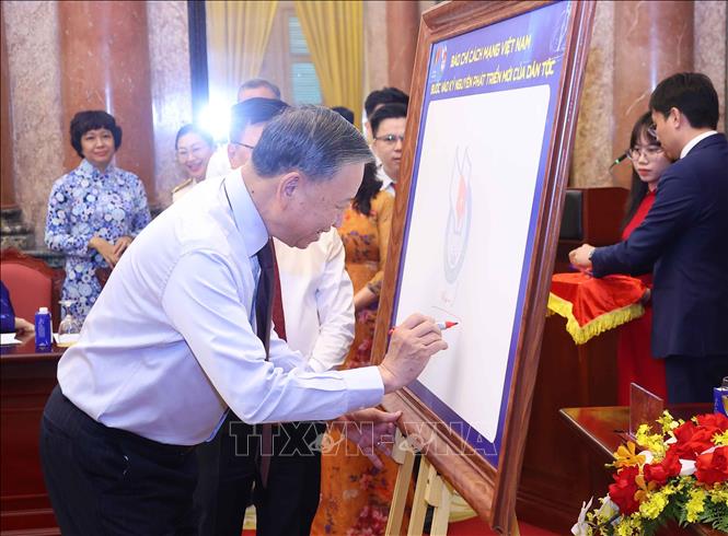 Tổng B&iacute; thư, Chủ tịch nước T&ocirc; L&acirc;m k&yacute; lưu niệm v&agrave;o biểu trưng của Hội Nh&agrave; b&aacute;o Việt Nam. Ảnh: Văn Điệp/TTXVN