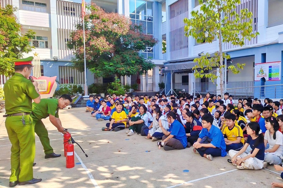 C&aacute;n bộ c&ocirc;ng an phường hướng dẫn học sinh sử dụng b&igrave;nh chữa ch&aacute;y đ&uacute;ng c&aacute;ch. Ảnh: Ngọc H&acirc;n