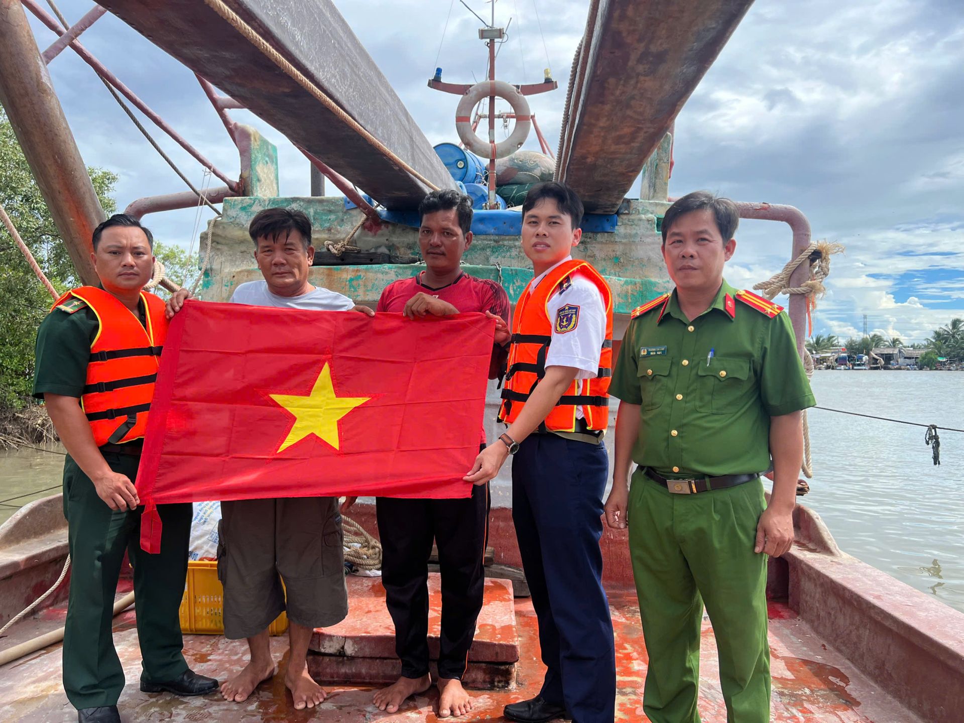 Tổ c&ocirc;ng t&aacute;c Hải đo&agrave;n 42 c&ugrave;ng với c&ocirc;ng an địa phương trao tặng cờ Tổ quốc cho ngư d&acirc;n
