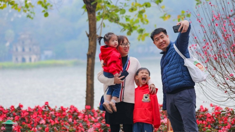 Cả gia đ&igrave;nh c&ugrave;ng nhau ghi lại khoảnh khắc của m&ugrave;a Xu&acirc;n b&ecirc;n hồ Gươm. (Ảnh: Thanh T&ugrave;ng/TTXVN)
