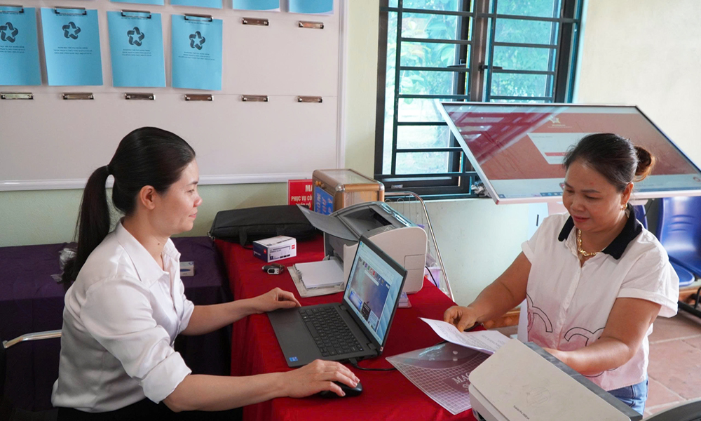 c&ocirc;ng d&acirc;n thực hiện giao dịch thủ tục h&agrave;nh ch&iacute;nh tại nh&agrave; văn h&oacute;a th&ocirc;n Việt Hương.