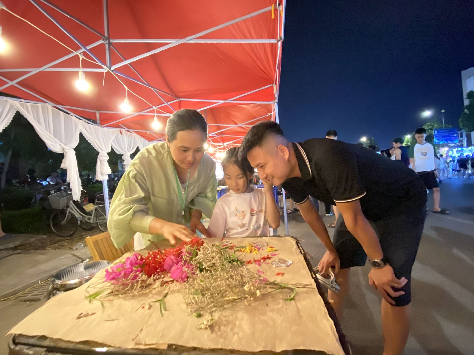 Du kh&aacute;ch trải nghiệm l&agrave;m giấy d&oacute; tr&ecirc;n tuyến phố đ&ecirc;m phường V&otilde; Cường.