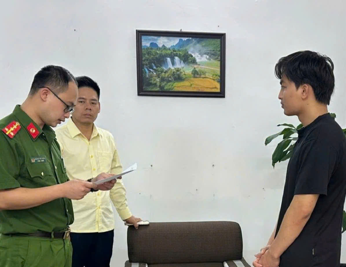 Nguyễn Quang Lợi (b&ecirc;n phải ảnh) nghe Quyết định khởi tố để điều tra về h&agrave;nh vi sản xuất, bu&ocirc;n b&aacute;n h&agrave;ng giả. (Ảnh: CACC)