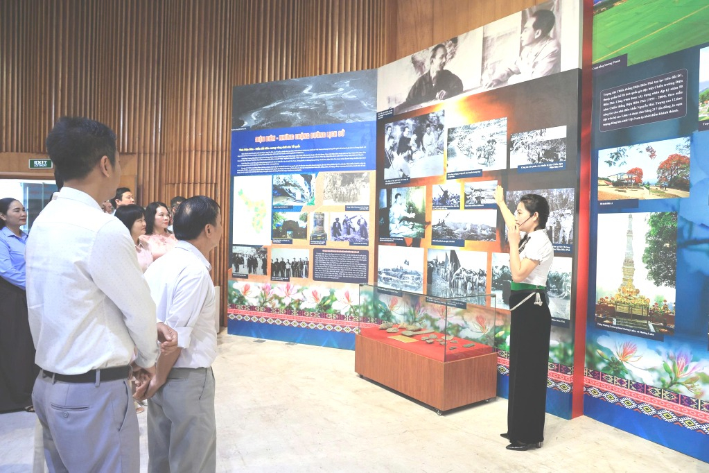 Đại biểu và du khách nghe thuyết minh viên giới thiệu về Chiến thắng Điện Biên Phủ Đại biểu và du khách nghe thuyết minh viên giới thiệu về Chiến thắng Điện Biên Phủ