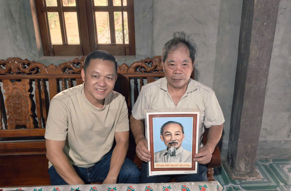 &Ocirc;ng N&ocirc;ng Văn Cắm (b&igrave;a phải) b&ecirc;n tấm ảnh Chủ tịch Hồ Ch&iacute; Minh vừa được thay mới.