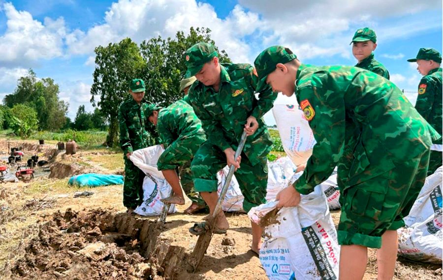Cán bộ, chiến sĩ Đồn Biên phòng Sông Trăng giúp Nhân dân đắp đê ngăn lũ Cán bộ, chiến sĩ Đồn Biên phòng Sông Trăng giúp Nhân dân đắp đê ngăn lũ