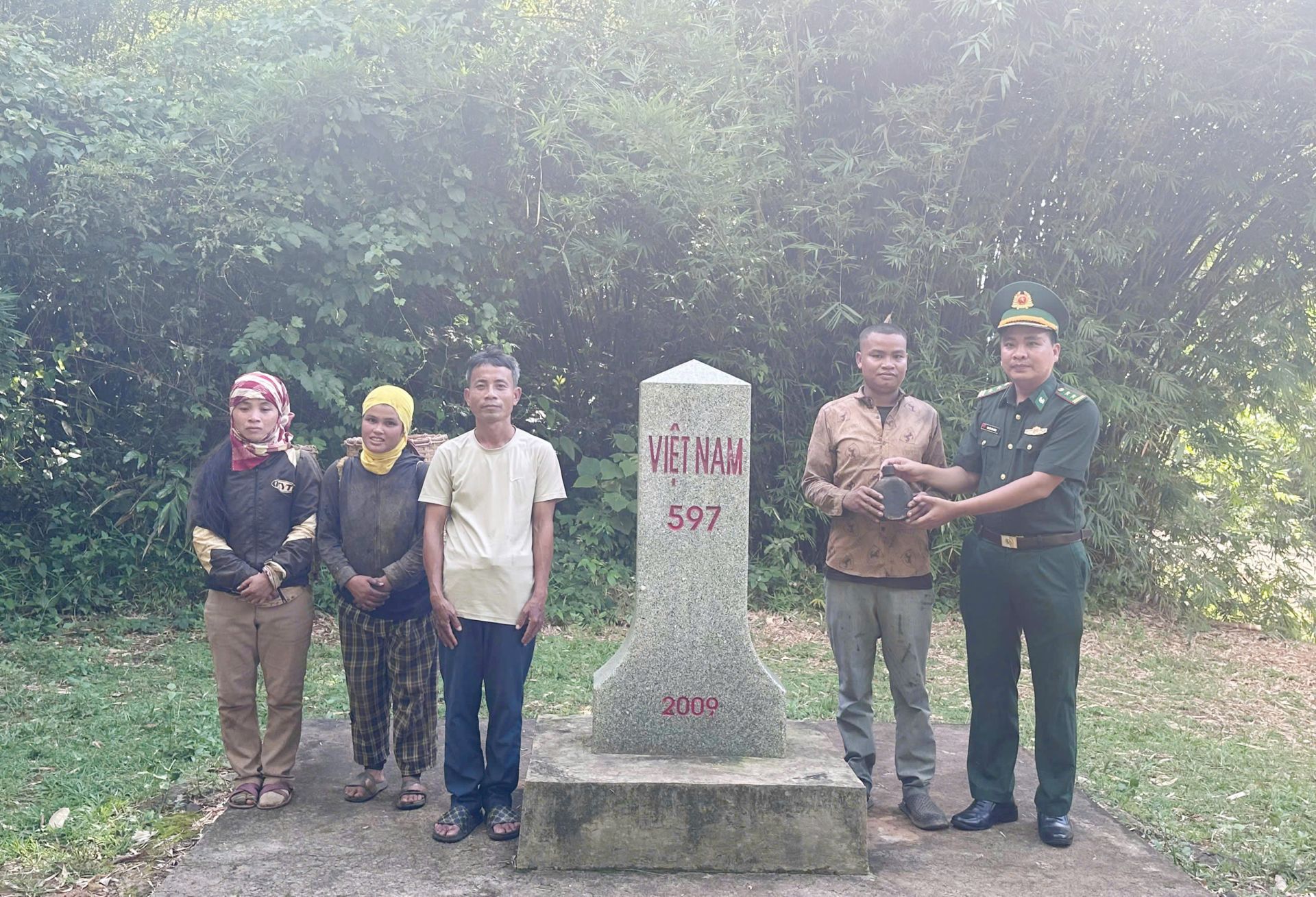 C&aacute;n bộ Đồn Bi&ecirc;n ph&ograve;ng Hướng Ph&ugrave;ng trao đổi với người d&acirc;n về phần mộ liệt sĩ tại khu vực mốc 597.