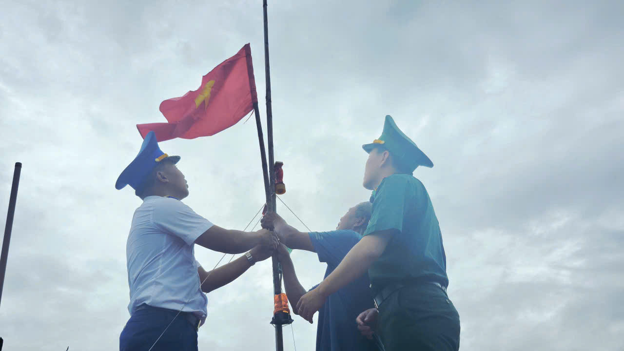 Đo&agrave;n c&ocirc;ng t&aacute;c c&ugrave;ng ngư d&acirc;n thay cờ Tổ quốc tr&ecirc;n t&agrave;u c&aacute; vươn khơi b&aacute;m biển.