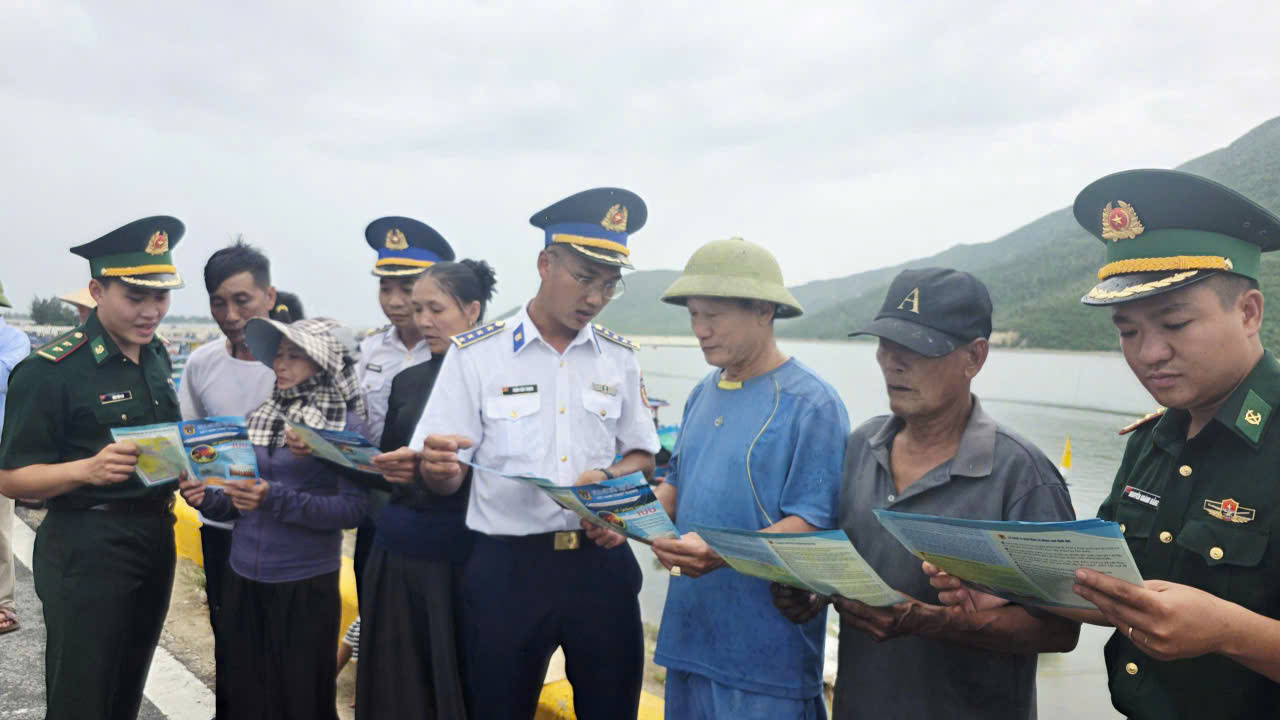 Ảnh 2. C&aacute;n bộ trong đo&agrave;n c&ocirc;ng t&aacute;c tuy&ecirc;n truyền, ph&aacute;t tờ rơi v&agrave; hướng dẫn ngư d&acirc;n thực hiện c&aacute;c quy định về chống khai th&aacute;c hải sản bất hợp ph&aacute;p (IUU).