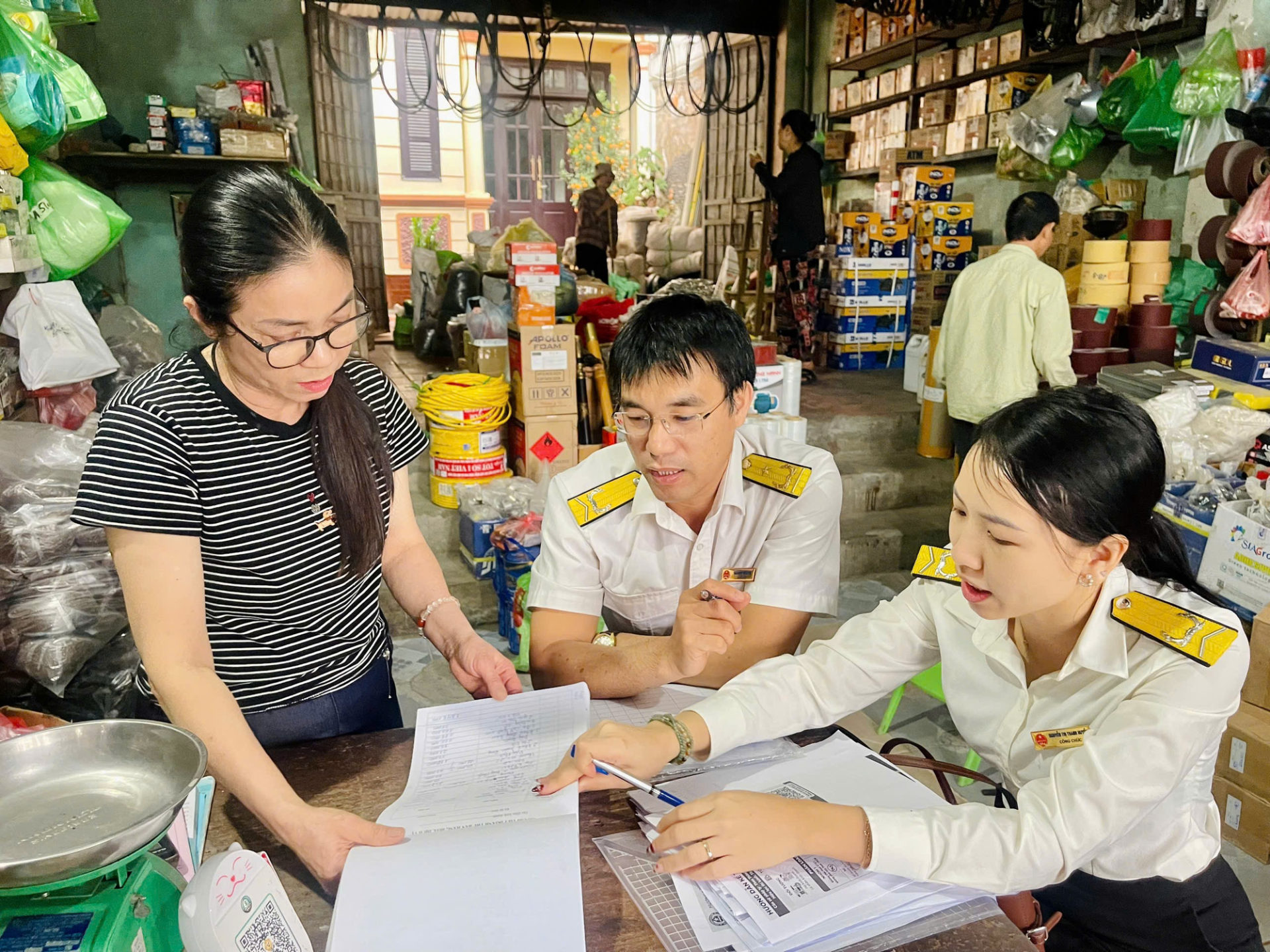 C&ocirc;ng chức ng&agrave;nh Thuế hướng dẫn hộ kinh doanh c&aacute;c quy định về Thuế. Ảnh: hanoi.gdt.gov.vn