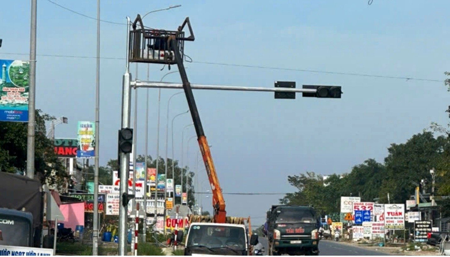 Lắp đ&egrave;n t&iacute;n hiệu giao th&ocirc;ng tr&ecirc;n QL1A thuộc x&atilde; H&agrave;m Thuận Nam, L&acirc;m Đồng. Ảnh PN