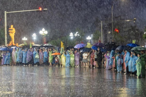Dù cơn mưa rào bất chợt thử thách lòng người, không khí lễ hội vẫn sục sôi. Hàng ngàn người dân vẫn kiên nhẫn bám trụ, đội mưa đứng dọc hai bên đường để không bỏ lỡ bất kỳ khoảnh khắc nào của đêm hội. Ảnh: Ánh Dương Dù cơn mưa rào bất chợt thử thách lòng người, không khí lễ hội vẫn sục sôi. Hàng ngàn người dân vẫn kiên nhẫn bám trụ, đội mưa đứng dọc hai bên đường để không bỏ lỡ bất kỳ khoảnh khắc nào của đêm hội. Ảnh: Ánh Dương