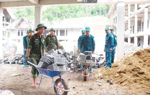 Lực lượng vũ trang hỗ trợ x&acirc;y trường Ch&uacute; th&iacute;ch: C&aacute;n bộ, chiến sĩ lực lượng vũ trang tỉnh Quảng Trị tham gia vận chuyển vật liệu, hỗ trợ thi c&ocirc;ng trường học tại khu vực bi&ecirc;n giới. Ảnh: Cổng th&ocirc;ng tin điện tử tỉnh Quảng Trị.