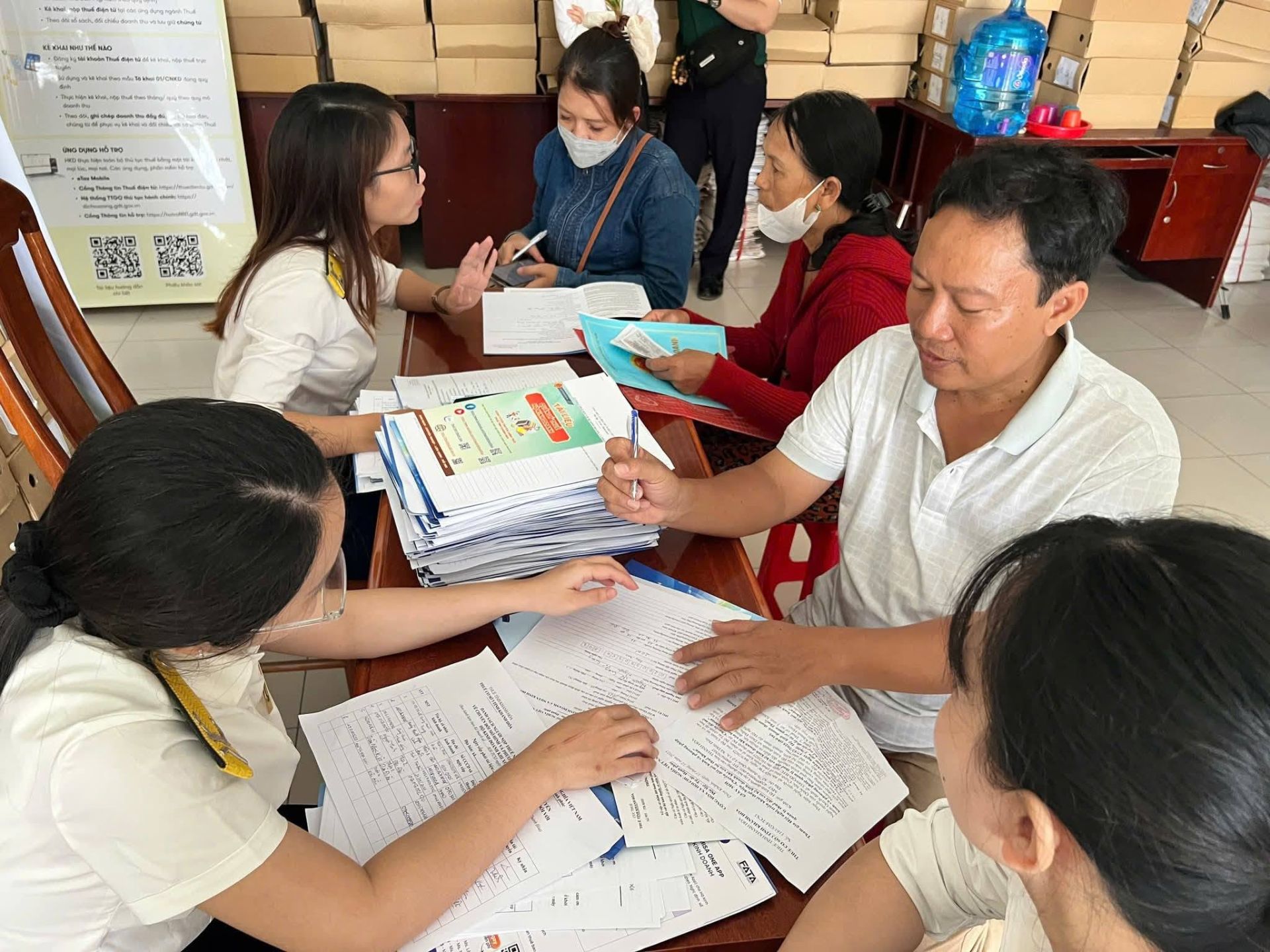 C&ocirc;ng chức Thuế tỉnh Kh&aacute;nh H&ograve;a hỗ trợ người nộp thuế l&agrave;m thủ tục chuyển đổi thuế. Ảnh: khanhhoa.gdt.gov.vn